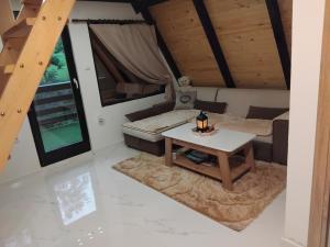 a living room with a table and a couch at Vikendica Djuric in Vlasenica