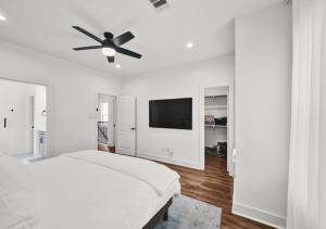 a white bedroom with a bed and a ceiling fan at Modern Home Suite, 2BR, Office, Near Galleria in Houston