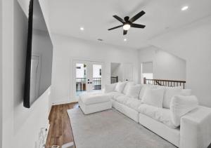 a white living room with a white couch and a ceiling fan at Modern Home Suite, 2BR, Office, Near Galleria in Houston