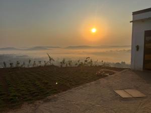 un'alba su un campo nebbioso con un edificio di Hilltop Haven Mpigi a Mpigi