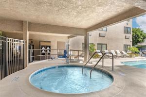 a hot tub on a patio next to a swimming pool at Best Western Plus Park Place Inn - Mini Suites in Anaheim