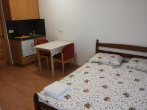 een kleine kamer met een bed, een tafel en een keuken bij Deima in Nida