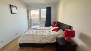 a bedroom with a bed with red pillows and a window at Your temporary home in Vienna in Vienna
