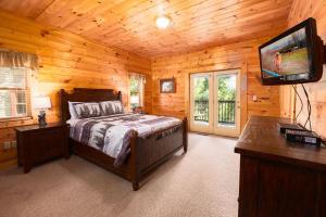 una camera con letto e televisore in una cabina di Bear Tracks a Gatlinburg