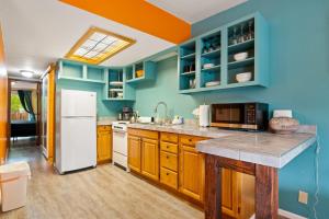 Una cocina con gabinetes de madera y un refrigerador blanco. en Charming 2 Bedroom Near Downtown - Rose Tree 1, en Moab
