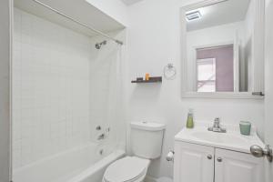 a white bathroom with a toilet and a sink at Charming Soulard Retreat with Historic Character near Baseball Stadium apts in Soulard