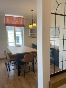 una cucina e una sala da pranzo con tavolo e sedie di Séjour Royal au Coeur de Calais a Calais Altre 3 foto