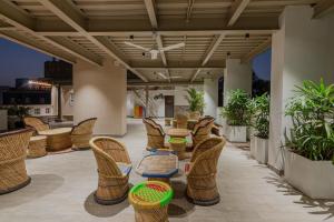 a patio with wicker chairs and tables on a balcony at Palm Residences and Suites in Jaipur