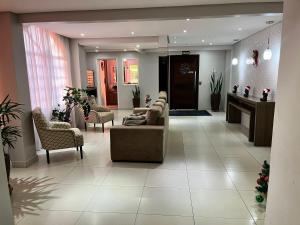 a lobby with couches and chairs in a building at Apartamento próximo ao Shopping Catuaí in Cascavel