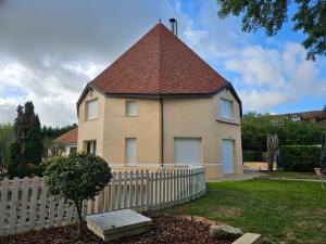 a house with a roof with a white fence at Le Pigeonnier in Venoy