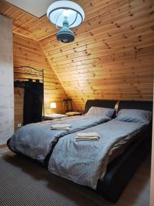 a bedroom with a large bed with a wooden ceiling at Przystanek Spokój - Nowe Siodło Sudety Środkowe in Nowe Siodło