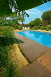 a swimming pool with two white chairs next to it at KEIKI Complejo Cabañas in Mar del Plata +14 photos
