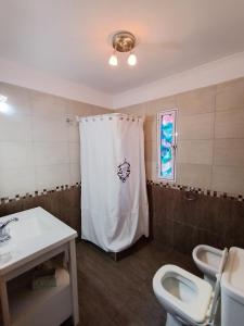 baño con cortina de ducha blanca y 2 aseos en La mejor quinta en Uribe, en Uribelarrea