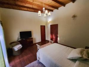 Un dormitorio con una cama y un televisor de pantalla plana. en La mejor quinta en Uribe, en Uribelarrea