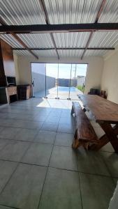 a large room with a wooden table on the floor at Edícula Roma - Casa de hóspedes in Campo Mourão