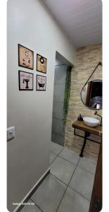 a bathroom with a sink and a table with a mirror at Edícula Roma - Casa de hóspedes in Campo Mourão