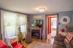 a living room with a television and a fireplace at New River Farmhouse on the New River & Stocked Fishing Creek in Crumpler