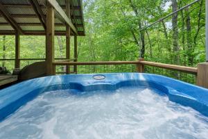 a hot tub on the deck of a house at By The New River - Hot Tub - Fireplace - Covered Porch in Glendale Springs