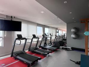 a gym with a bunch of treadmills in a room at Conforto na Liberdade - AC e Quarto privativo in Sao Paulo
