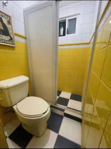 a yellow bathroom with a toilet and a shower at Bonita casa en Oaxaca in Oaxaca City