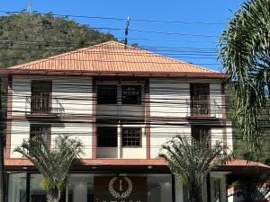 un edificio bianco con alberi di fronte di Apartamento em Itaipava a Petrópolis