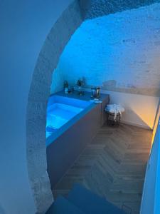 a bath tub in a room with a blue light at DORO' suite & luxury rooms in Noci