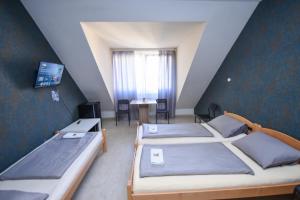 a room with three beds and a table and a window at Moderne Appartement in Nürnberg