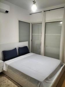 a bedroom with a large white bed with blue pillows at Agadir Best Apparts in Agadir nʼ Aït Sa +35 photos