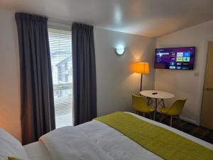 a hotel room with a bed and a table and a window at MetroStay Manchester in Manchester