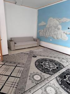a room with a mural of clouds on the wall at The Homely Stay in Bukhara +3 photos