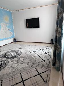 a room with a tiled floor with a television on a wall at The Homely Stay in Bukhara