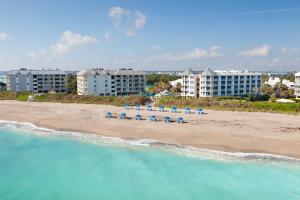 an aerial view of a beach with beach chairs and buildings at Beach House Suites in Stuart