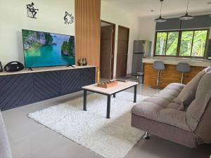 a living room with a couch and a table and a tv at Zout Villas in Thong Sala