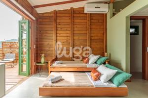 a room with two beds and a wooden wall at Refúgio pé na areia na Caieira - Espaço completo in Florianópolis