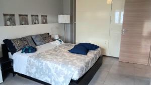Un dormitorio con una cama con dos almohadas azules encima. en SOPHIE HOME Torino, Nuovissima vicino Juventus Stadium, en Turín