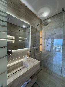 a bathroom with a tub and a shower with a sink at marina1 in Agadir +9 photos