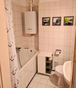 a bathroom with a tub and a toilet and a sink at Kreatives Studio in der City von Osnabrück in Osnabrück