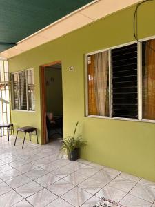 a green house with a patio with a window at Alma Delfina in San Isidro de El General