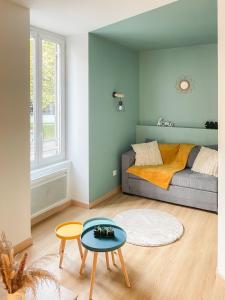 a living room with a couch and a table at Cocon design centre ville proche gare in Mâcon
