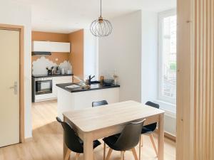 a kitchen and dining room with a table and chairs at Cocon design centre ville proche gare in Mâcon