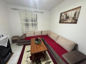 a living room with a couch and a table at Apartment Bushi in Pukë