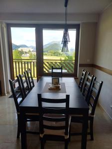 a dining room table with chairs and a large window at Apartman Donovaly Panorama 31C 4i in Donovaly