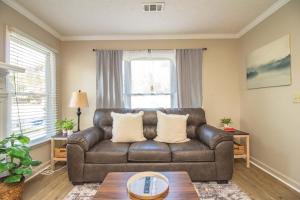 a brown leather couch in a living room with a table at Columbus Cornerstone in Columbus