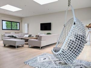 a living room with a hanging hammock at Maison spacieuse et lumineuse in Lys-lez Lannoy