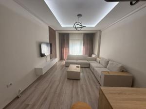a living room with a couch and a tv at Amaji Apartament Korcë in Korçë
