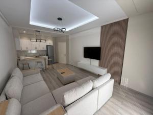 a living room with a couch and a kitchen at Amaji Apartament Korcë in Korçë