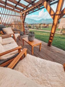 a wooden deck with couches and a table with a view at Liptovalley- mobilné domy s wellnessom in Liptovská Kokava +66 photos