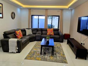 a living room with a couch and a coffee table at Zachi Zebra Apartment in Kitwe +2 photos
