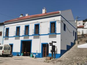 a white and blue building with blue windows at Casa Fidal in Bordeira