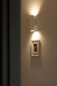 a light on a wall with a picture on it at Jules Home in Sibiu